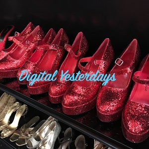 Puede incluir: Una exhibición de zapatos de plataforma rojos con purpurina y correas en el tobillo. Los zapatos están colocados en una estantería con otros pares de zapatos en el fondo. El texto "Digital Yesterdays" es visible.
