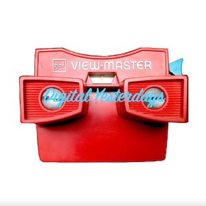 May include: A red View-Master toy with the words "VIEW-MASTER" printed on the front. The toy has two round viewing lenses and a blue handle.