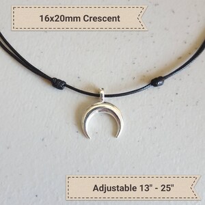 May include: A silver crescent moon pendant necklace on a black adjustable cord. The pendant is 16x20mm and the cord is adjustable from 13 to 25 inches.