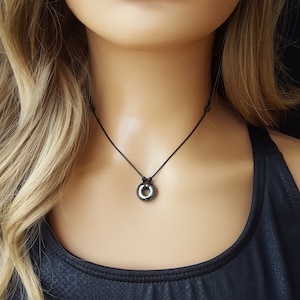 May include: A black necklace with a small, round, black hematite pendant.