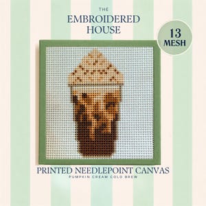 May include: A square needlepoint canvas featuring a printed design of a pumpkin cream cold brew coffee drink. The canvas has a green border and includes the text THE EMBROIDERED HOUSE, 13 MESH, and PRINTED NEEDLEPOINT CANVAS PUMPKIN CREAM COLD BREW.