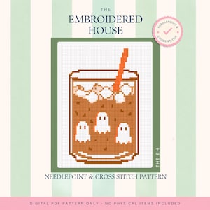 May include: A cross stitch pattern titled The Embroidered House featuring a pixelated illustration of a glass filled with brown liquid, ice cubes, and three small white ghosts, with an orange straw, on a white grid background with green borders.