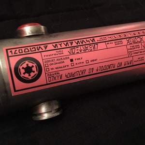 May include: A pink and black label with the text "120000", "MOLTOLEYRNA", "FVK7", "KYM40177 SV &yen;7000M7N OU KN", "ЕИЛОМ", and "4152728822". The label also features a black and white symbol with a circle and four spokes.