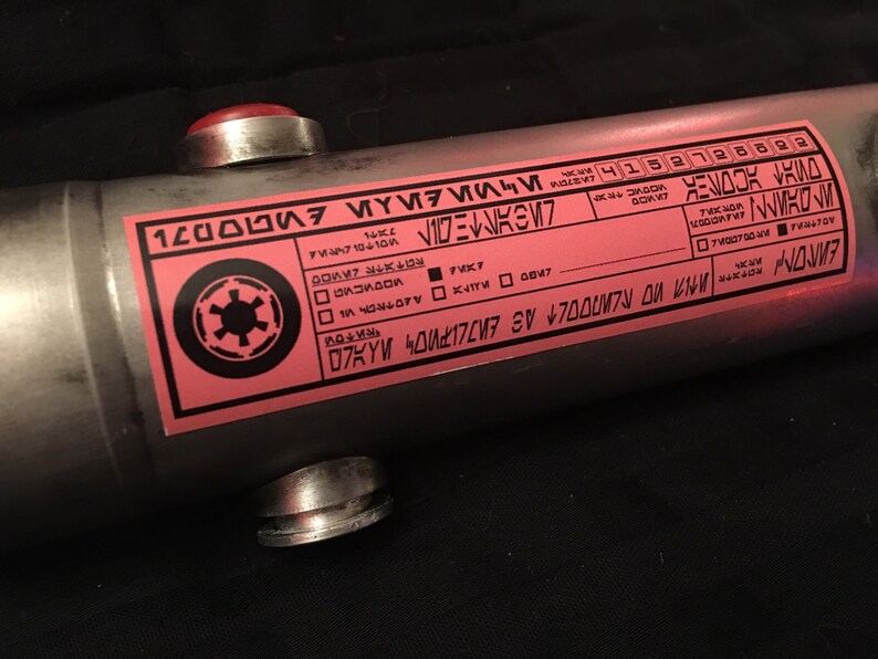 May include: A pink and black label with the text "120000", "MOLTOLEYRNA", "FVK7", "KYM40177 SV &yen;7000M7N OU KN", "ЕИЛОМ", and "4152728822". The label also features a black and white symbol with a circle and four spokes.