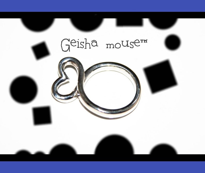 May include: A silver ring with a heart-shaped design. The ring is on a white background with black circles and squares. The text "Geisha mouse&trade;" is written on the background.