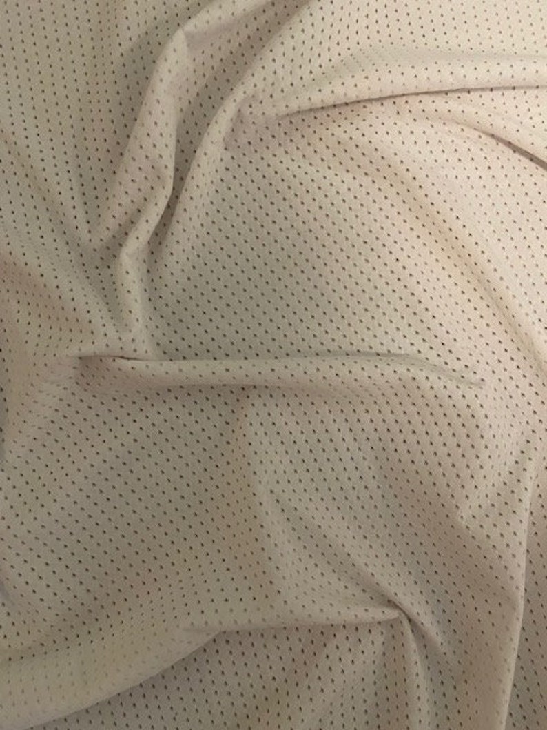 May include: Close-up of a white mesh fabric with a small, repeating diamond pattern. The fabric is soft and has a slightly textured surface.