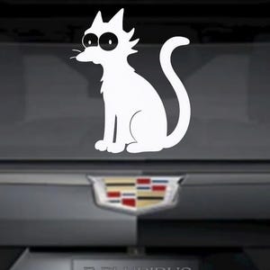 May include: White vinyl decal of a cartoon cat with large, round eyes and a curved tail. The cat is sitting, facing left. The decal is on a dark gray surface, with the text "E PLURIBUS UNUM Est. 2018" visible below.