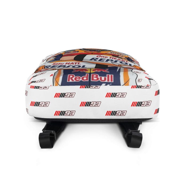 Puede incluir: Una mochila blanca con un patr&oacute;n repetitivo del n&uacute;mero 93 en negro y rojo. El panel superior muestra un gr&aacute;fico con el texto One Heart, Satu Hati, Repsol y logotipos de Red Bull en colores naranja, azul y blanco con correas negras.
