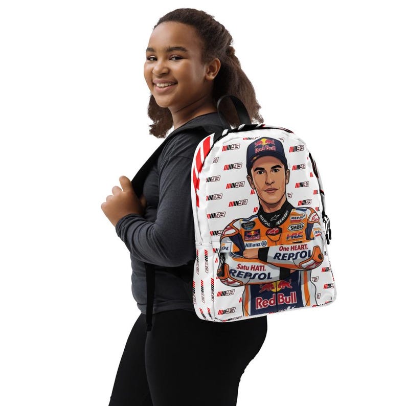 Puede incluir: Una mochila blanca con un patr&oacute;n repetitivo del n&uacute;mero 93 y un gr&aacute;fico central de un piloto de motos con un traje de carreras Repsol Honda y la marca Red Bull. El dise&ntilde;o incluye detalles de rayas rojas y blancas en el panel lateral.