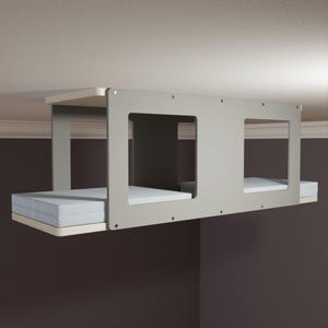 Puede incluir: Una cama gris para gatos montada en la pared con dos compartimentos. Cada compartimento tiene un cojín blanco y está enmarcado por una estructura gris claro. La cama está diseñada para montarse en una pared, proporcionando una solución que ahorra espacio para los dueños de mascotas.