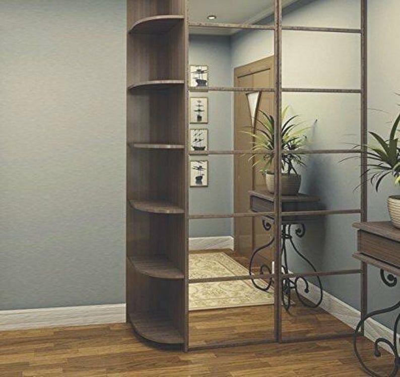 Pu&ograve; includere: Un'unit&agrave; a mensola d'angolo con cinque ripiani, realizzata in legno con finitura marrone scuro. I ripiani sono curvi nella parte anteriore e presentano un design decorativo. L'unit&agrave; si trova in una stanza con una parete a specchio dietro.