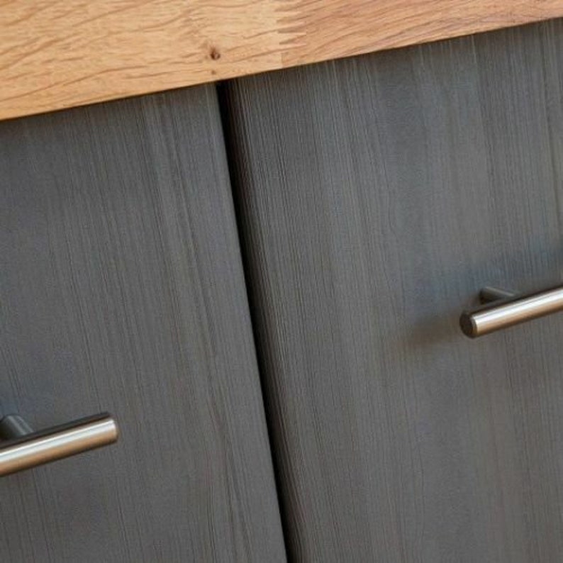 May include: Two gray wooden cabinet doors with silver metal handles. The doors have a wood grain pattern.