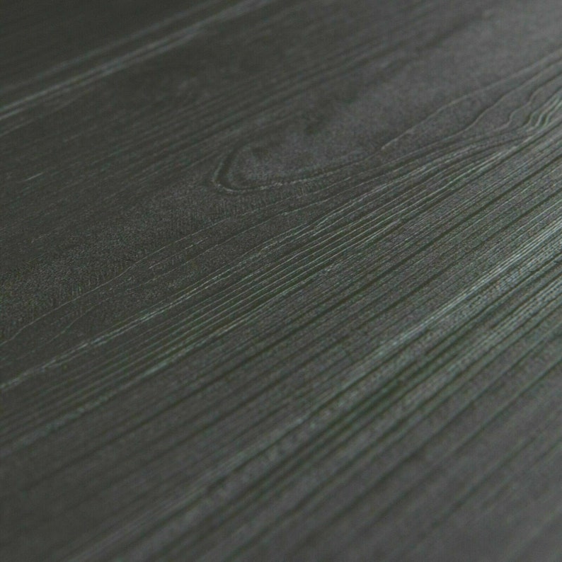 May include: Close-up of a dark gray wood grain surface. The wood grain is visible and has a slight sheen.