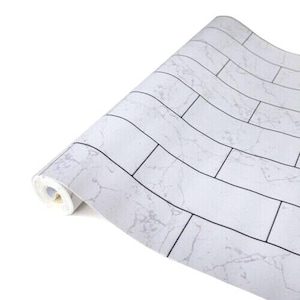 May include: White self-adhesive contact paper with a marble brick pattern. The paper is rolled up and ready to be unrolled.