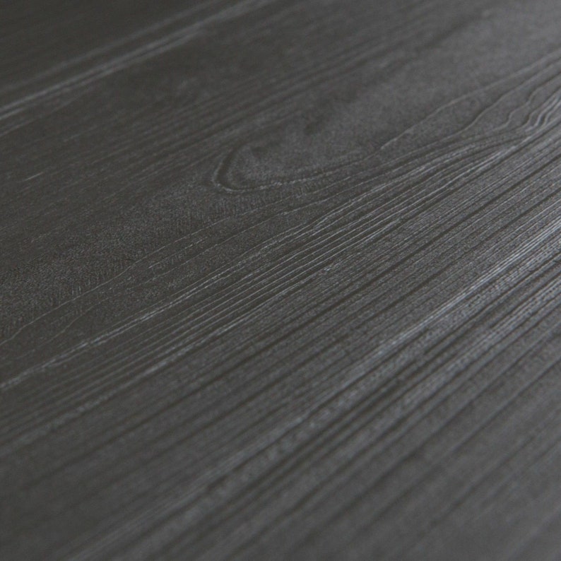May include: Close-up of a dark gray woodgrain surface.