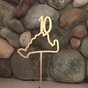 May include: Gold table number with the number 10 and an outline of the state of Virginia. The table number is on a gold metal stand.