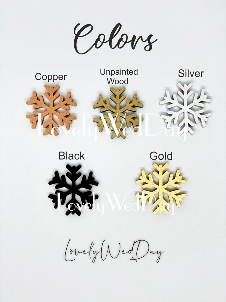 May include: Five wooden snowflake ornaments in different colors: copper, unpainted wood, silver, black, and gold. The snowflakes are arranged in two rows, with the copper, unpainted wood, and silver snowflakes in the top row and the black and gold snowflakes in the bottom row. The text "Colors" is written at the top of the image, and the text "Lovely Wed Day" is written at the bottom of the image.