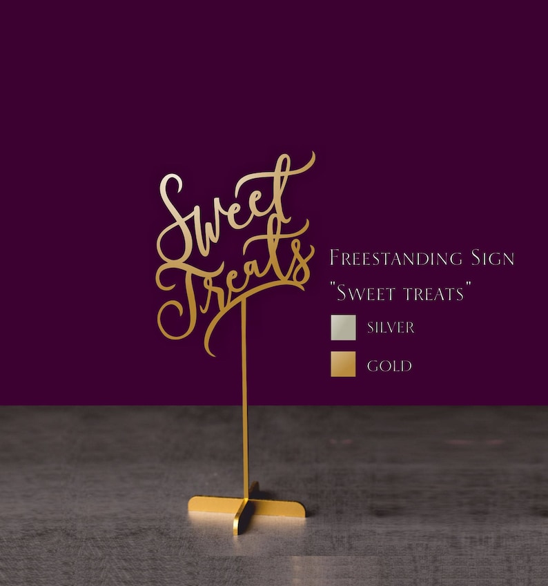May include: Gold freestanding sign with the words "Sweet Treats" in a decorative script font. The sign is on a gold stand with a cross base. The sign is available in silver or gold.