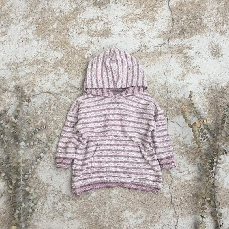 Op de afbeelding: Een roze en wit gestreepte hoodie met een kangoeroezak. De trui is gemaakt van een zachte, gebreide stof.