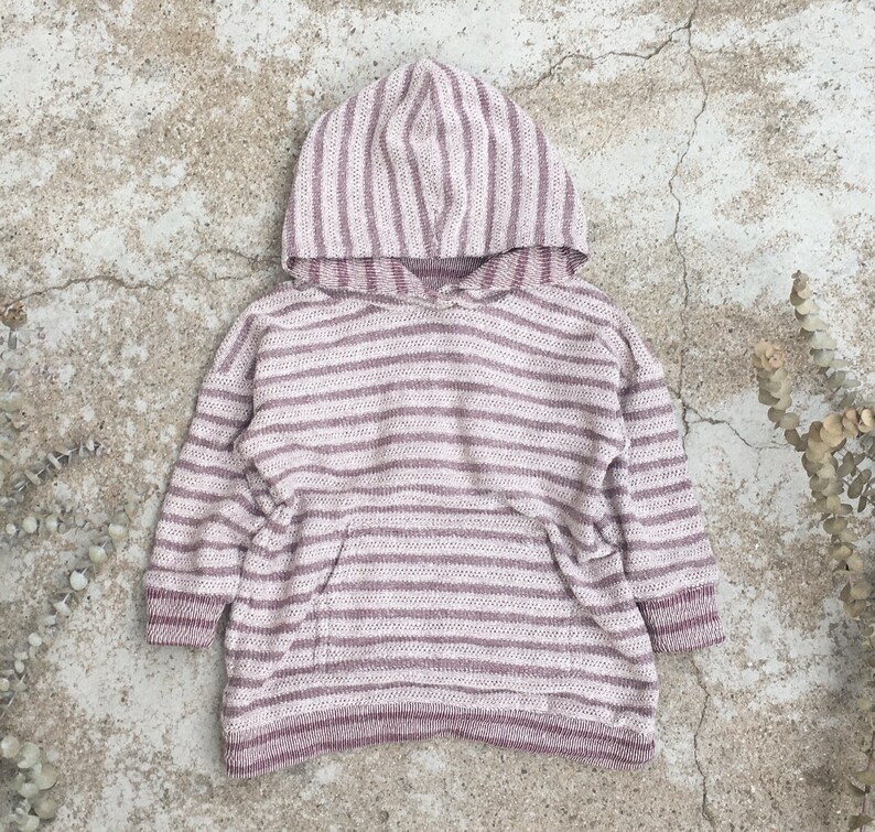 May include: A pink and white striped hooded sweater with a kangaroo pocket.