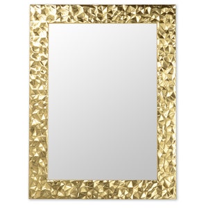 Könnte beinhalten: Ein goldfarbener Spiegel mit einem strukturierten, geometrischen Rahmen. Der Rahmen hat eine gehämmerte Metalloptik.
