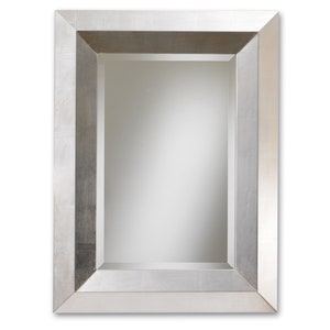 May include: A silver framed mirror with a simple, rectangular design. The frame has a slightly textured surface.