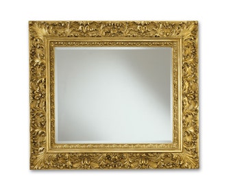 May include: A large, ornate gold mirror with a heavily carved frame. The frame is detailed with intricate floral patterns and has a slightly distressed finish.