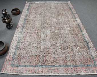 Puede incluir: Una alfombra vintage con un patrón floral descolorido en tonos rosa, azul y gris. La alfombra tiene un aspecto desgastado y un borde deshilachado.