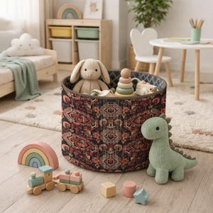 May include: A round storage bin with a patterned design, filled with toys. A plush bunny, wooden stacking rings, and a green dinosaur toy are visible. Other toys include a wooden train and a rainbow arch.
