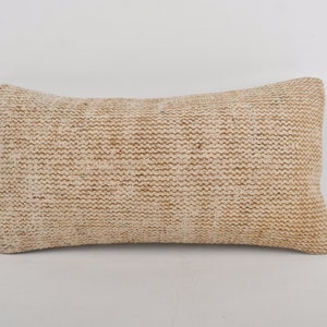 May include: A beige rectangular throw pillow with a woven texture.