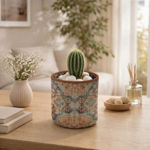 May include: A set of three ceramic mugs with a speckled, matte finish. The mugs are in shades of cream, light gray, and dark gray. Each mug has a simple, minimalist design and a rounded handle.