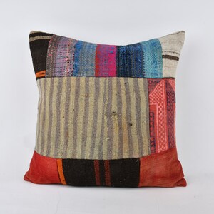 May include: A patchwork pillow cover with a variety of colors and patterns, including red, blue, and brown. The pillow cover is made from recycled materials and has a unique, handmade look.