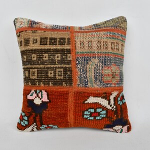 May include: A patchwork pillow cover with a variety of colors and patterns, including orange, blue, brown, and white. The pillow cover is made of woven fabric and has a fringed edge.
