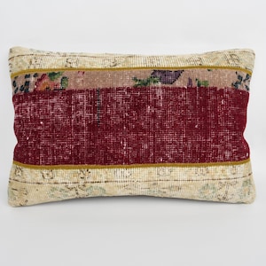 May include: Rectangular decorative pillow with a burgundy center panel, floral patterned middle band, and a beige border. The pillow has a textured appearance, suggesting a woven or embroidered design. The color palette includes burgundy, beige, and floral accents.