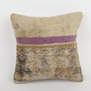 Pode incluir: Almofada decorativa quadrada com textura tecida em bege, castanho e roxo. A almofada apresenta uma faixa roxa horizontal e uma seção inferior estampada. O item é para decoração de casa.