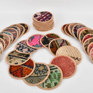 May include: A set of 20 round woven coasters with colorful patterns. The coasters are made from recycled rug material and have a beige border.
