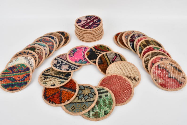 May include: A set of 20 round woven coasters with colorful patterns. The coasters are made from recycled rug material and have a beige border.