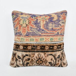 May include: A decorative throw pillow with a colorful floral pattern and a brown and beige border. The pillow is made from a woven fabric and has a vintage look.