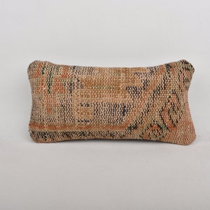 May include: A rectangular throw pillow with a brown, orange, green, and blue patterned fabric.