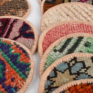 May include: A stack of colorful round woven coasters with a leather trim. The coasters feature various patterns and colors, including red, blue, green, and orange.