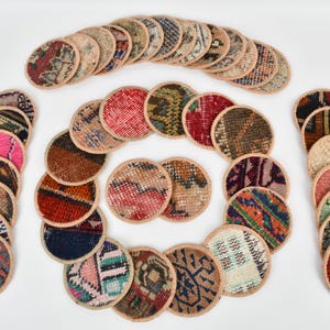 May include: A set of 25 round coasters made from repurposed fabric scraps. The coasters feature a variety of colorful patterns and designs.