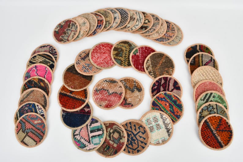 May include: A set of 25 round coasters made from repurposed fabric scraps. The coasters feature a variety of colorful patterns and designs.