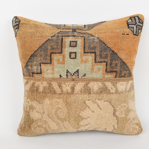 Peut inclure: Coussin carré décoratif avec un motif géométrique dans les tons orange, marron et beige. Le coussin présente une section supérieure à motifs et une section inférieure texturée, créant un attrait visuel unique. Le coussin est de forme carrée.