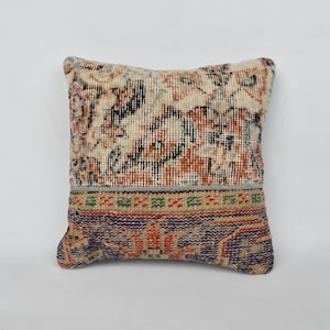 May include: A decorative throw pillow with a colorful floral pattern. The pillow is made from a patchwork of different fabrics and has a fringed edge.