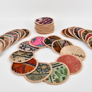 May include: A set of round, colorful coasters made from woven fabric with a beige border. The coasters are arranged in a circle with a stack of coasters in the background.