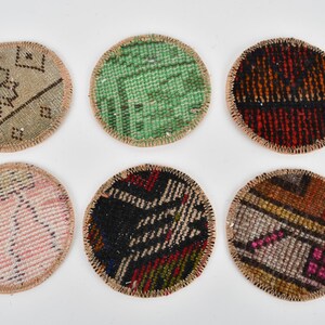 May include: Six round coasters made from colorful patterned fabric with a beige border. The coasters are approximately 3 inches in diameter.