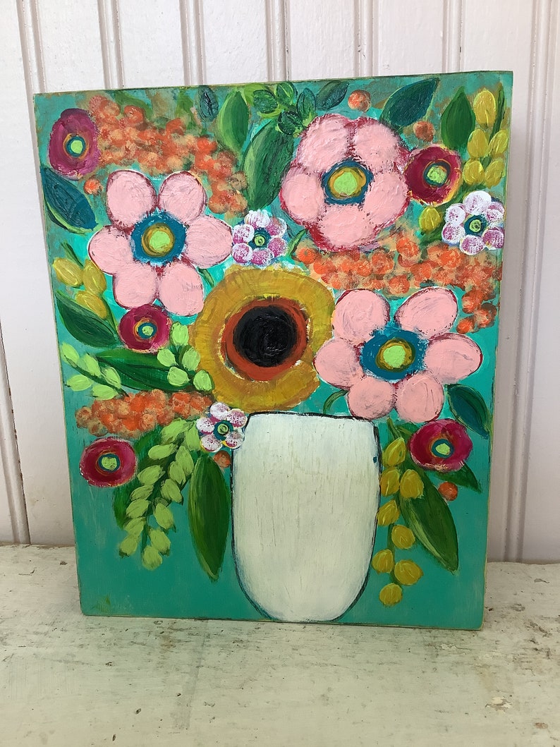 May include: A rectangular painting on a wooden panel featuring a bouquet of stylized flowers in a white vase against a vibrant turquoise background. The artwork displays pink, yellow, orange, and red blossoms with green leaves and textured brushstrokes.