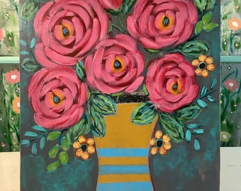 May include: A rectangular painting on a flat surface featuring a bouquet of large, textured pink roses with yellow centers in a mustard yellow vase with horizontal light blue stripes, surrounded by small orange flowers and green leaves on a dark background.