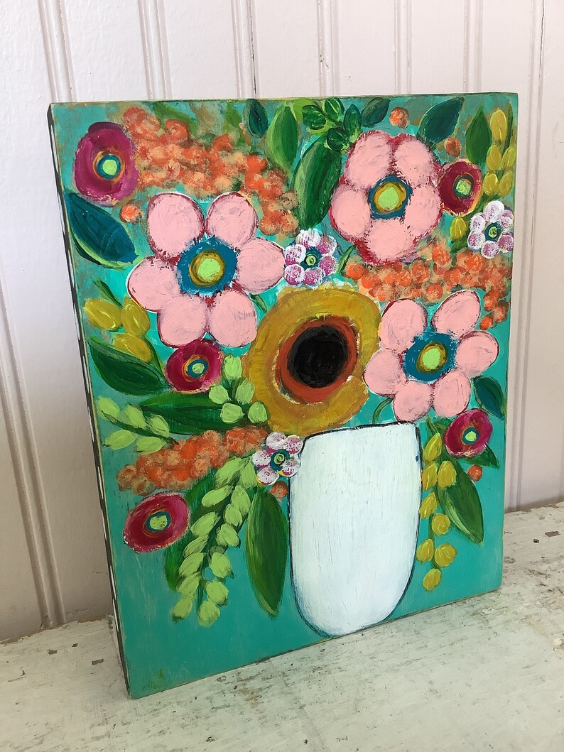 May include: A rectangular painting on a wooden panel featuring a vibrant floral arrangement in a white vase against a bright turquoise background. The artwork displays pink, yellow, and red flowers with green leaves and orange textured accents.