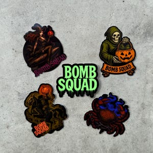May include: A collection of Halloween-themed stickers featuring various designs. Includes a witch riding a missile, a grim reaper with a pumpkin, a skeleton riding a horse, a crab, and the text "BOMB SQUAD".